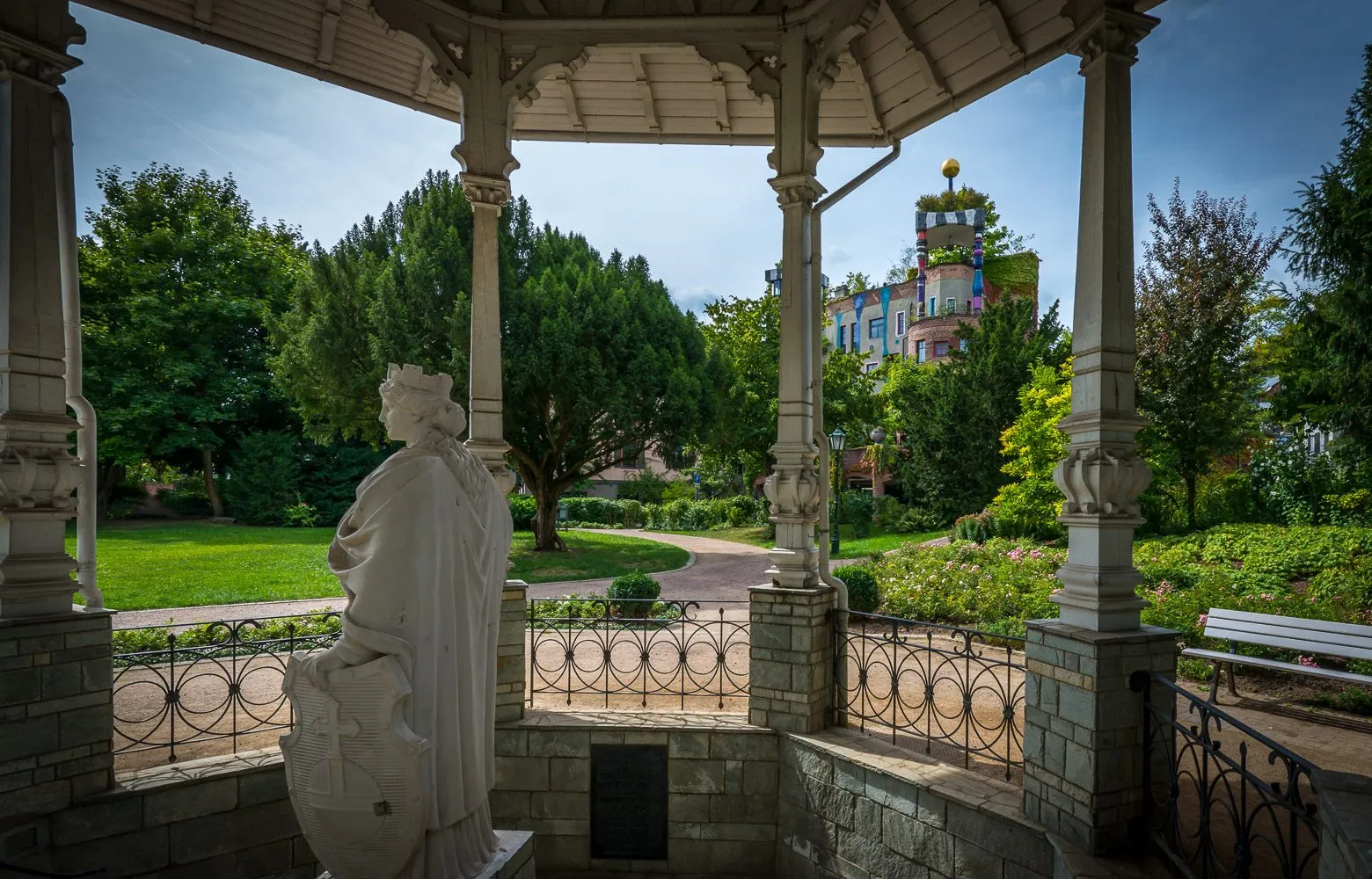 Pavillon im Alten Kurpark von Bad Soden mit Statue, im Hintergrund das Hundertwasserhaus